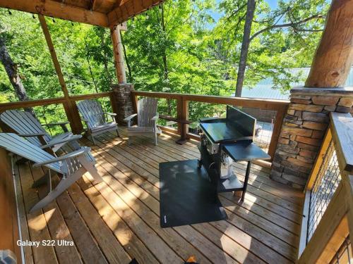 een afgeschermde veranda met een grill en 2 stoelen bij Dancing Bear Cabin- Relax & Enjoy! in Sevierville