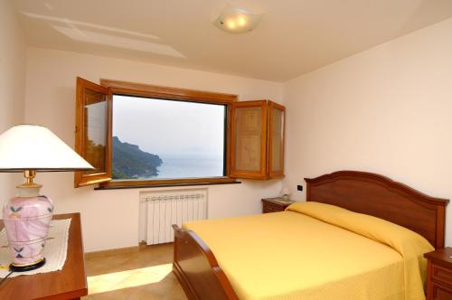 een slaapkamer met een geel bed en een raam bij Casa Rossa in Ravello