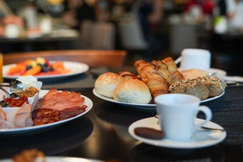 uma mesa com pratos de pastelaria e uma chávena de café em Hilton Belgrade em Belgrado