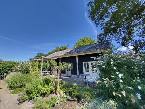 un cottage fleuri dans le jardin dans l'établissement Logeren bij De Soerensesteeg, à Uddel