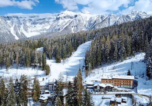 ein Skigebiet im Schnee mit Bergen im Hintergrund in der Unterkunft Hotel Selva in Folgarida