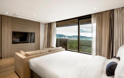 a bedroom with a large bed and a large window at Kensington Resort Gyeongju in Gyeongju