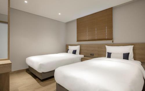 a bedroom with two beds and a window at Kensington Resort Gyeongju in Gyeongju