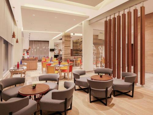 um átrio com mesas e cadeiras e uma cafetaria em ibis Kochi City Centre - An Accor Brand em Cochin