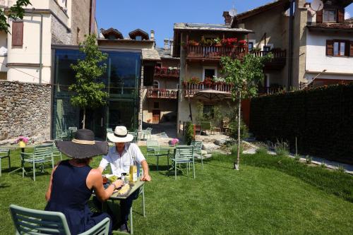 duas pessoas sentadas numa mesa num jardim em Relais Bondaz em Aosta