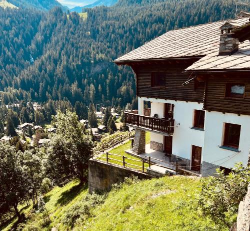 una casa en una colina con vistas a un valle en Affittacamere Buenavista Guest House, en Champoluc