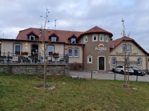 un bâtiment avec une voiture garée devant lui dans l'établissement Hotel & Restaurace Pizzerie Jasany, à Znojmo