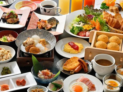 een tafel met veel borden eten erop bij Himeji Castle Grandvrio Hotel in Himeji