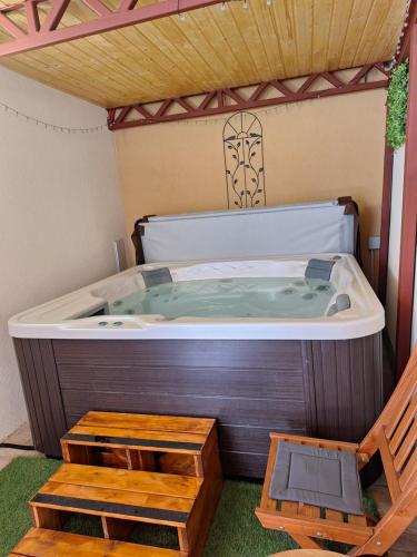 a hot tub in a room with a table and a bench at Várfal apartman II in Eger