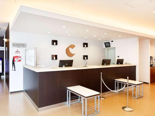 a lobby with a counter with laptops on it at Comfort Hotel Himeji in Himeji