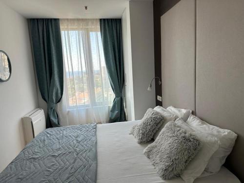 um quarto com uma cama com almofadas e uma janela em Victoria Apartments em Budva