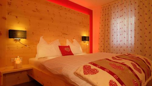 1 dormitorio con 1 cama grande con iluminación roja en Residence Tamperhof, en San Candido