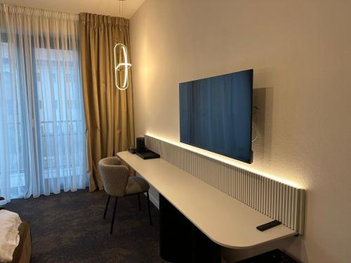 a hotel room with a desk with a flat screen tv at Element in Alba Iulia