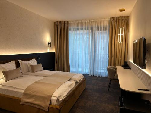 a hotel room with a large bed and a television at Element in Alba Iulia