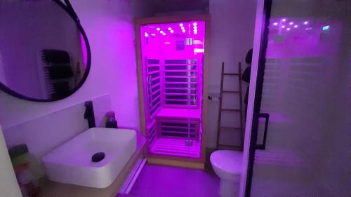 圣普列斯特Arty Appart - Sauna en option, Parking box privé, Balcon的浴室设有粉红色的灯光、卫生间和水槽