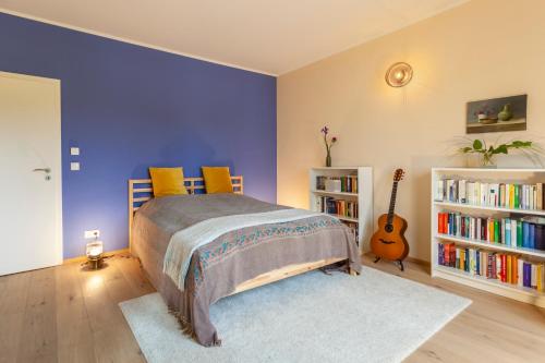 - une chambre avec un lit et une guitare dans l'établissement Stilvolles Ambiente im grünen Hamburg!, à Hambourg