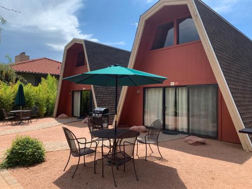 een tafel en stoelen met een parasol voor een gebouw bij Red Agave Resort in Sedona