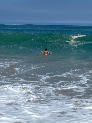 a man is swimming in the ocean at Playa Norte Experience in Punta Hermosa