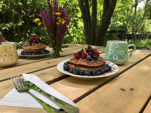 a wooden table with two cakes with berries on it at River side SVANETI in Mestia