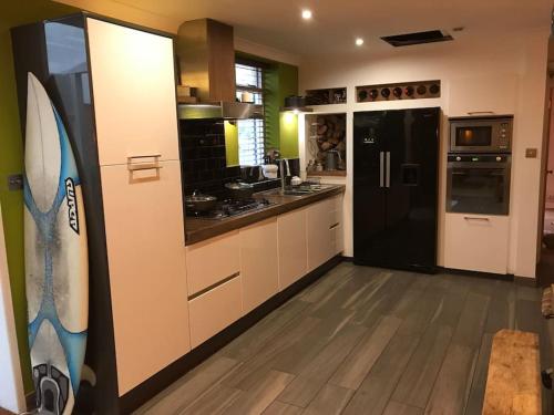 a kitchen with a black refrigerator and a counter at Large cosy flat in Southbourne near beaches in Bournemouth