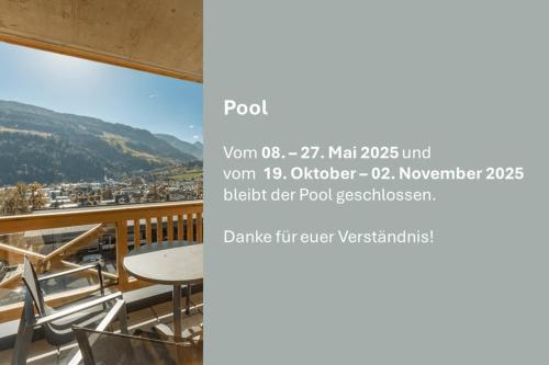 einen Bildschirm mit einem Balkon mit einem Tisch und Stühlen in der Unterkunft Apartmentresort MyLodge in Schladming