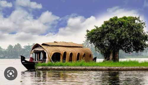 una barca con tetto di paglia seduta in acqua di Kalappura Houseboats & Tours a Alleppey