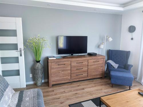 una sala de estar con TV en una cómoda de madera en Apartament Nadmorski, en Gdynia