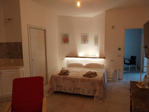 a bedroom with a bed and a red chair at MarMè in San Teodoro