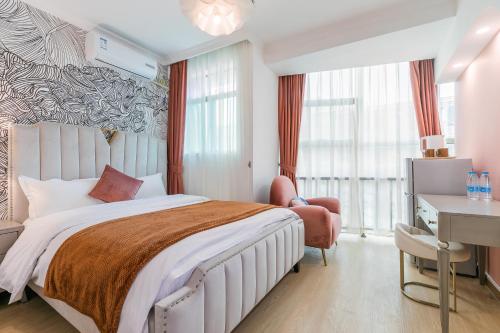 um quarto com uma cama grande, uma secretária e uma cadeira. em Vanhome Serviced Apartment 梵宿公寓 em Guangzhou