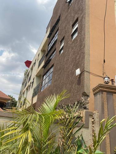 un alto edificio di mattoni con alberi di fronte di Javelin Hotel , Kampala, Uganda a Kampala