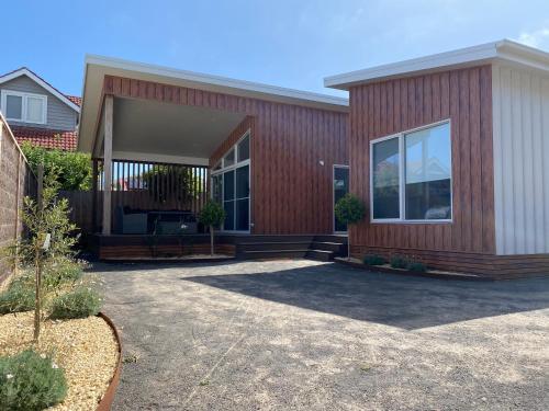 Ein Haus mit einem roten Gebäude mit einer Terrasse in der Unterkunft Central Hideaway-close to everything in Warrnambool