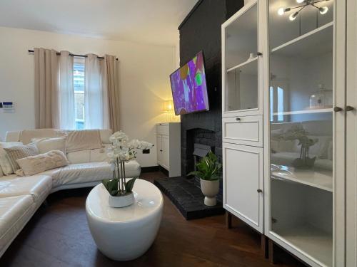 a living room with a white couch and a tv at Slick Space for a Standish Stay in Standish