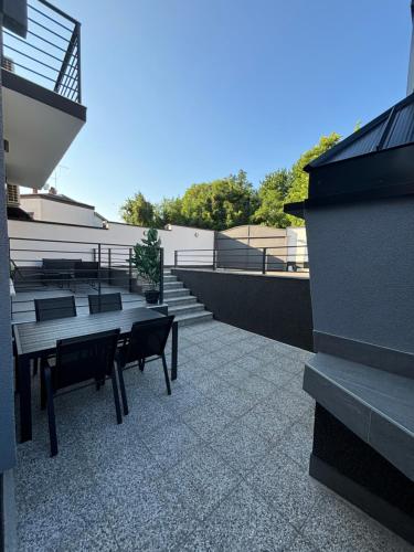 een patio met een tafel en banken in een gebouw bij Vila Galerija in Vukovar