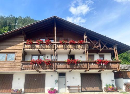 un edificio con fiori rossi sui balconi di Stroblhof a Vipiteno