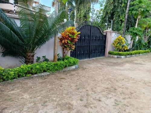 un cancello nero in un cortile con piante di Mudzini gardens - Luxury villa with a pool a Mombasa