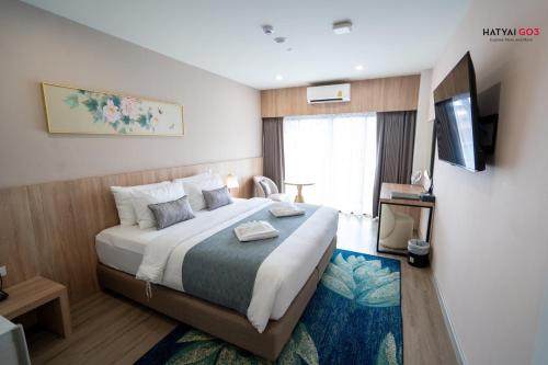 a hotel room with a bed and a television at Chinatown Living Hatyai in Hat Yai