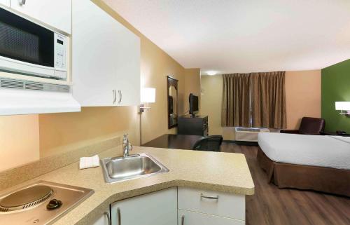 een keuken met een wastafel en een kamer met een bed bij Extended Stay America Suites - Salt Lake City - West Valley Center in West Valley City