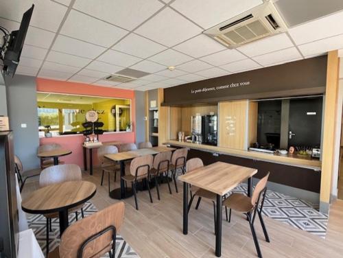 un restaurant avec des tables, des chaises et un comptoir dans l'établissement B&B HOTEL PERPIGNAN Nord Aéroport, à Perpignan