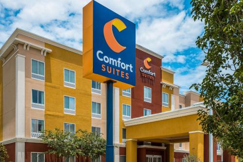 um sinal em frente a um edifício com um hotel em Comfort Suites Denham Springs em Denham Springs