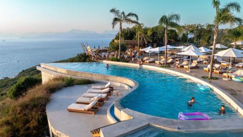 een zwembad met ligstoelen en de oceaan bij Arameras Beach Resort in Ksamil