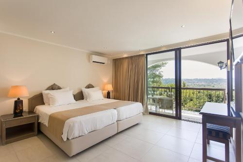 - une chambre avec un grand lit et un balcon dans l'établissement Corfu Holiday Palace, à Corfou