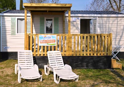 dos sillas y una mesa frente a una casa pequeña en Happy Camp Mobile Homes in Camping Laguna Village, en Caorle