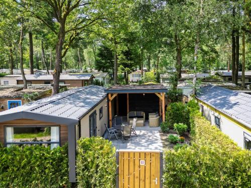 - une vue sur une petite maison avec un garage dans l'établissement VELUWE HOENDERLOO LUXURY CHALETS WITH PRIVATE SAUNA AND HOT TUB - Swimming Pool Tennis Court Supermarket Bowling Alley Theatre and Entertainment for Children, à Hoenderloo