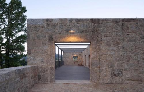 un pasillo en un edificio de piedra con una pasarela de madera en Quinta do Outeiro 1598, en Ponte da Barca