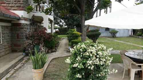 a garden with a table and a bunch of flowers at Taphe Resort Naivasha in Naivasha