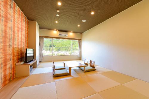 um quarto com uma mesa e cadeiras e uma televisão em Ooedo Onsen Monogatari Hotel Kinugawa Gyoen em Nikko