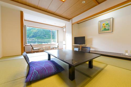 uma sala de jantar com uma mesa e uma janela em Ooedo Onsen Monogatari Hotel Kinugawa Gyoen em Nikko