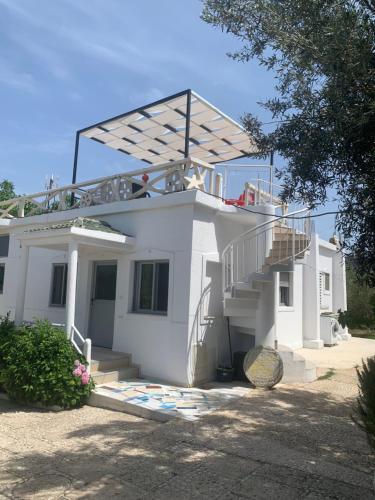 une maison blanche avec des escaliers et un toit dans l'établissement Villas Ermali, à Ksamil