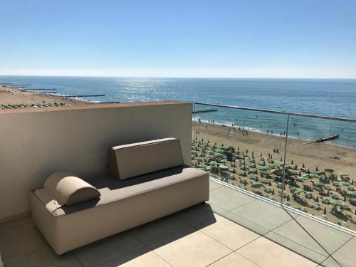 a balcony with a tv and a view of a beach at Hotel Ancora in Lido di Jesolo