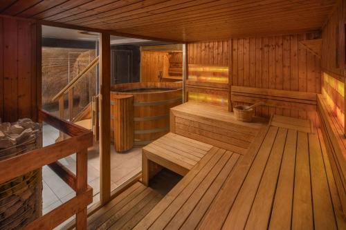 eine Sauna mit Holzböden, Bänken und einer Badewanne in der Unterkunft Sungarden Wellness Hotel Siófok in Siófok